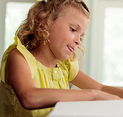 A young female child named Quinn concentrates intently on her homework while sitting at a table